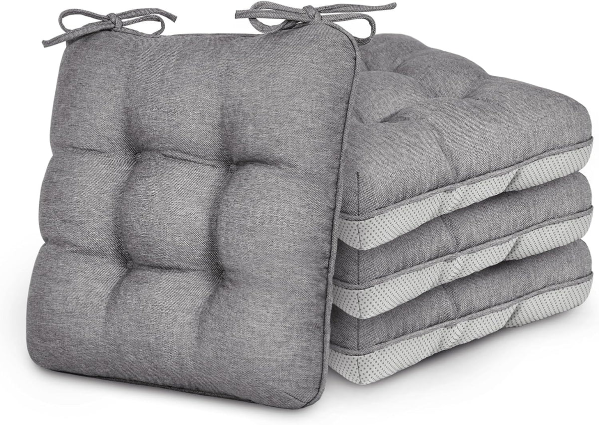 Stack of four gray tufted square chair cushions with ties, two facing forward and two stacked on their sides
