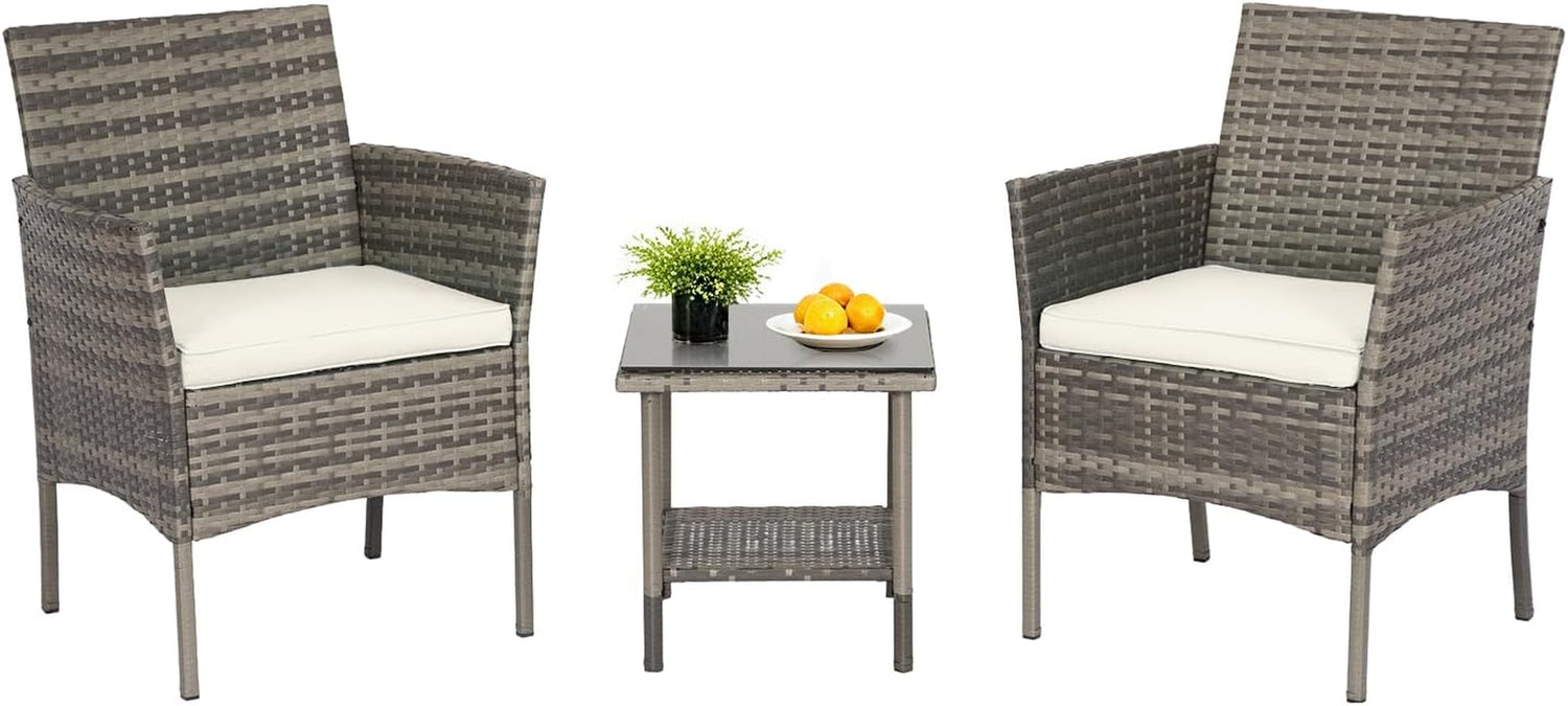 Pair of light gray-brown woven rattan armchairs with off-white cushions and a matching square glass-top side table with