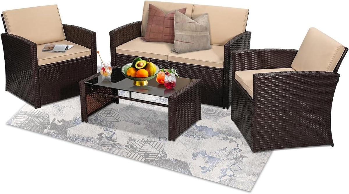 Brown wicker loveseat and two armchairs with beige cushions and glass-top coffee table on a patterned rug.