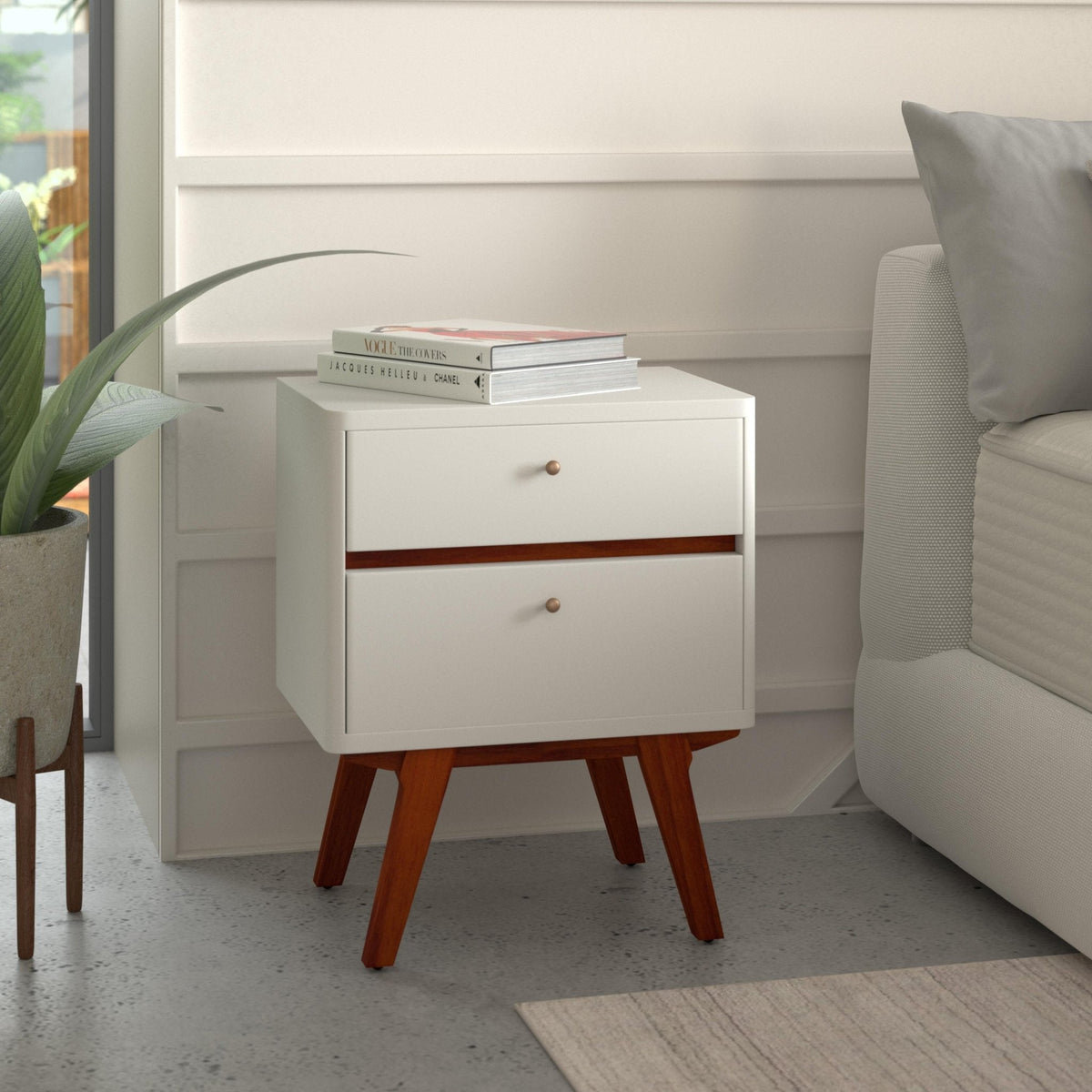 White two-drawer nightstand with acorn accents beside a bed in a bright bedroom
