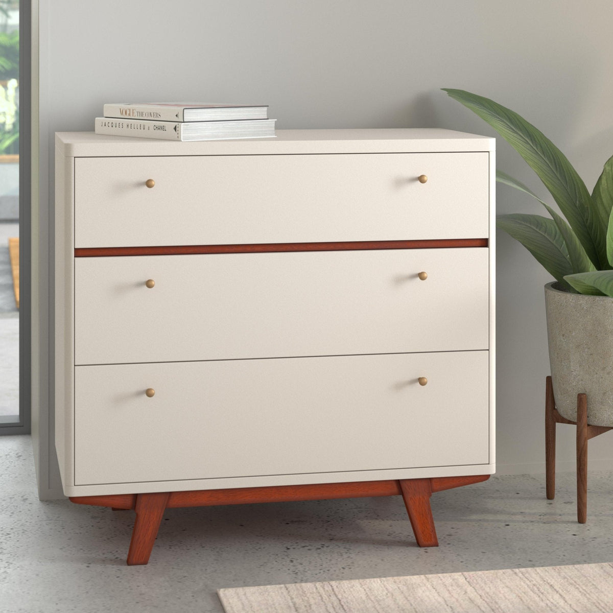 White three-drawer chest with acorn accents shown at an angle in a bright room
