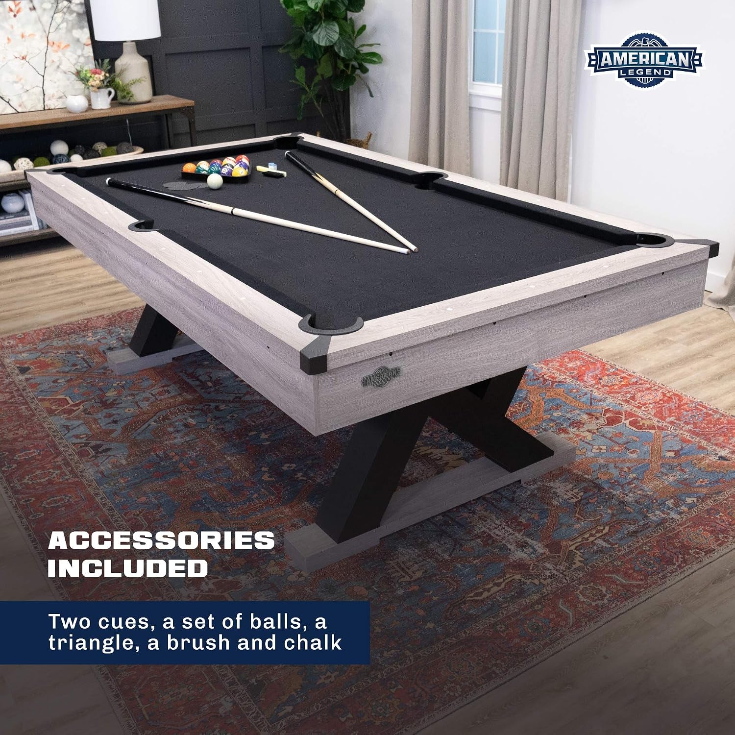 Top-side angle of the table showing two cues, a triangle and racked balls resting on the black playing cloth.