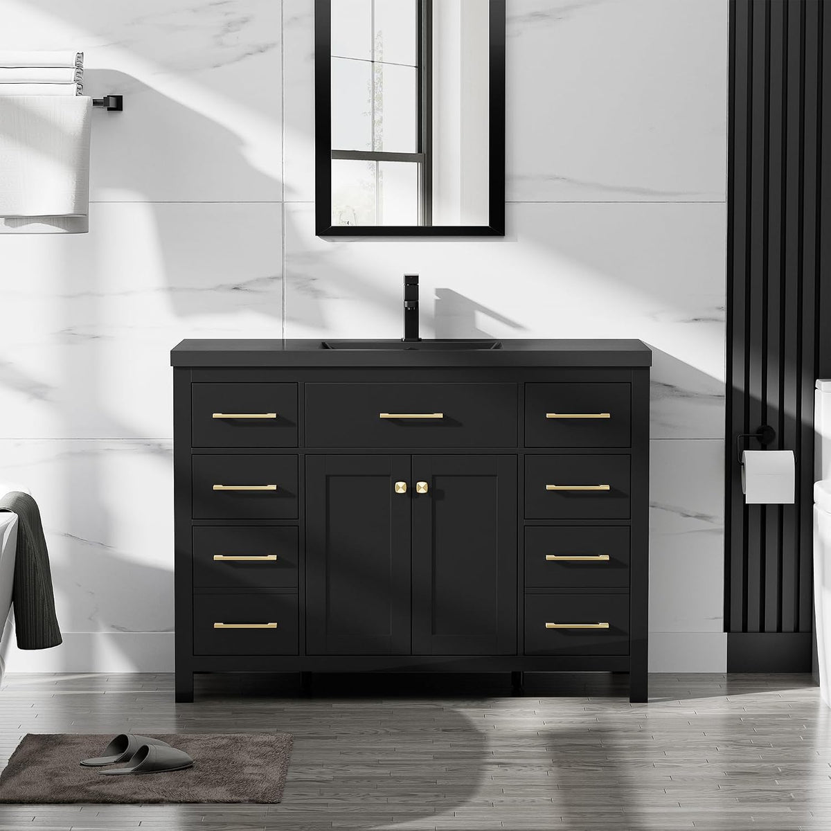 Straight-on shot of a black vanity with gold handles, centered faucet and a rectangular mirror above.