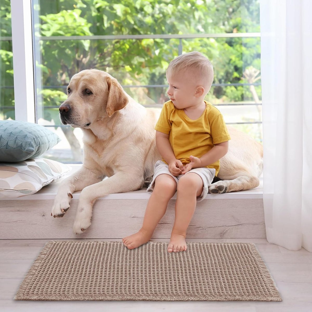 Tan waffle bath mat on the floor with a child sitting on a windowsill and a dog beside them.