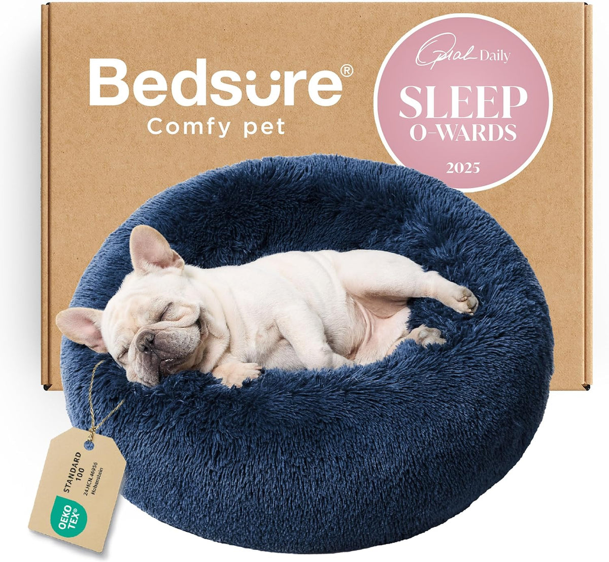 Front view of a navy blue fluffy donut bed with a sleeping light-colored bulldog curled inside, box in background
