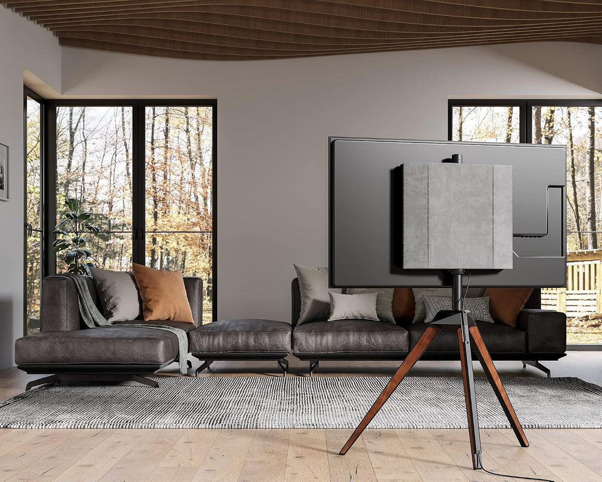 Rear view of tripod TV stand showing wooden legs and mounted TV in a spacious living room.