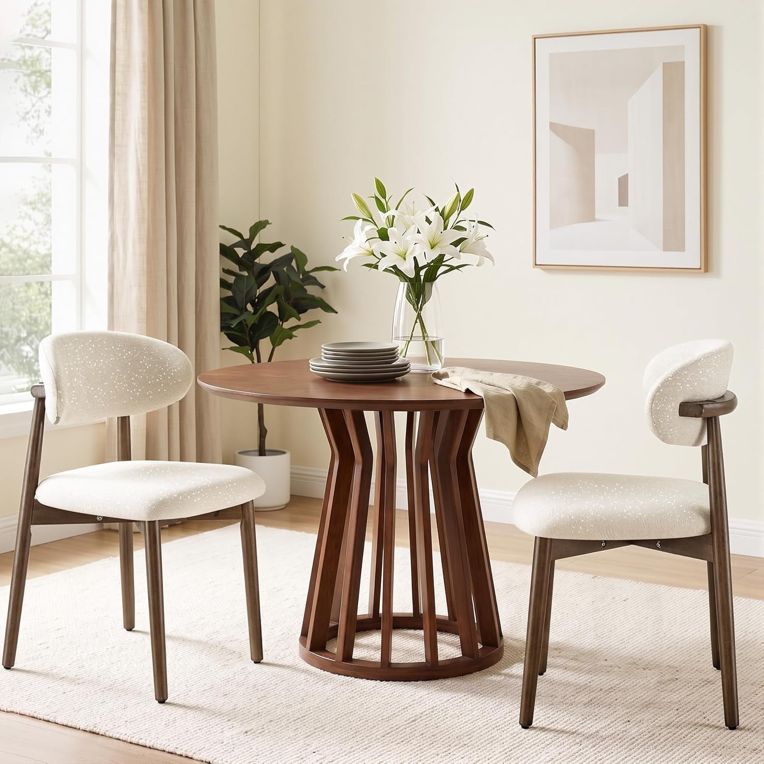 Two cream-speckled curved-back chairs flank a round dining table in a softly lit room.