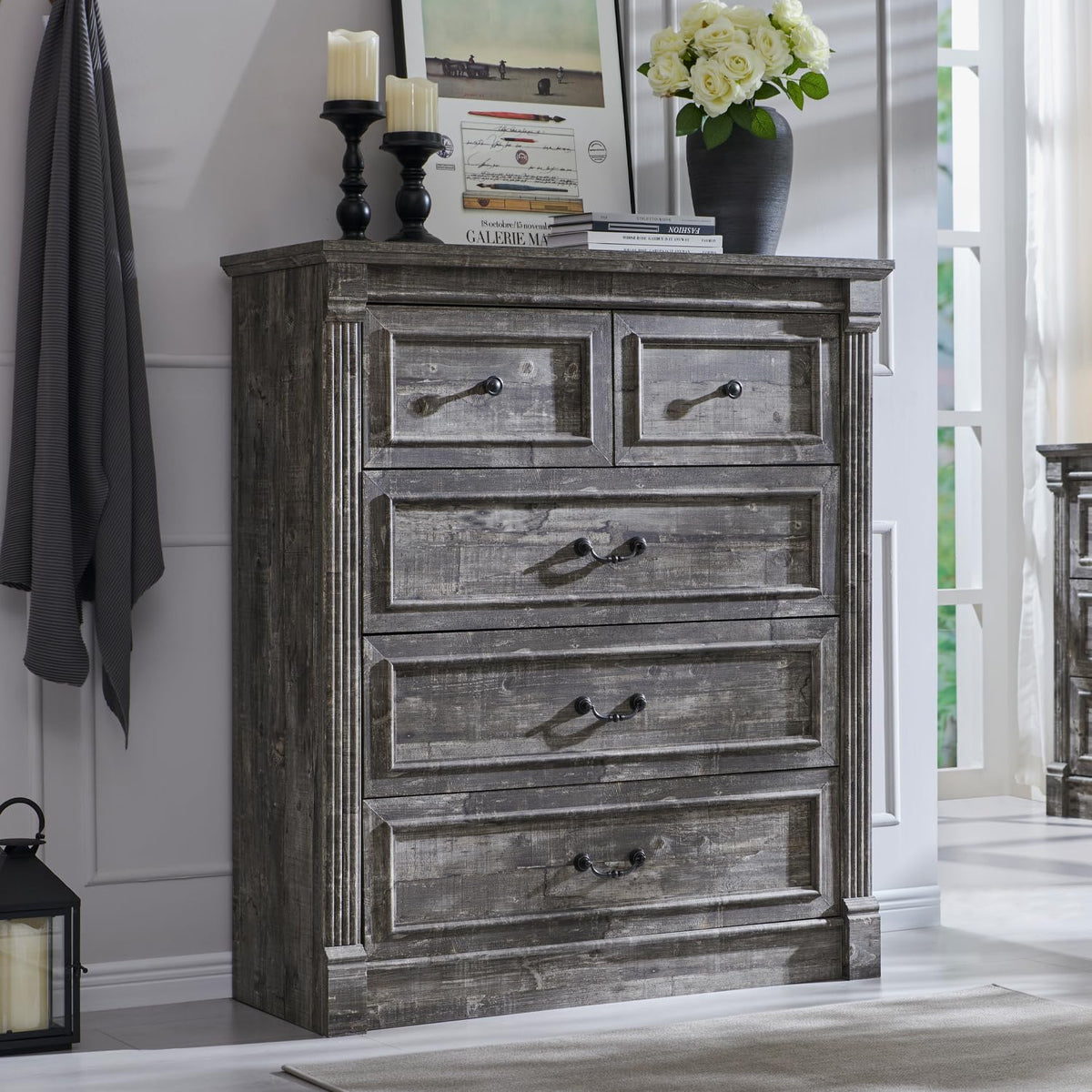 Tall five-drawer chest in weathered gray wood with decorative column corners and metal pulls.