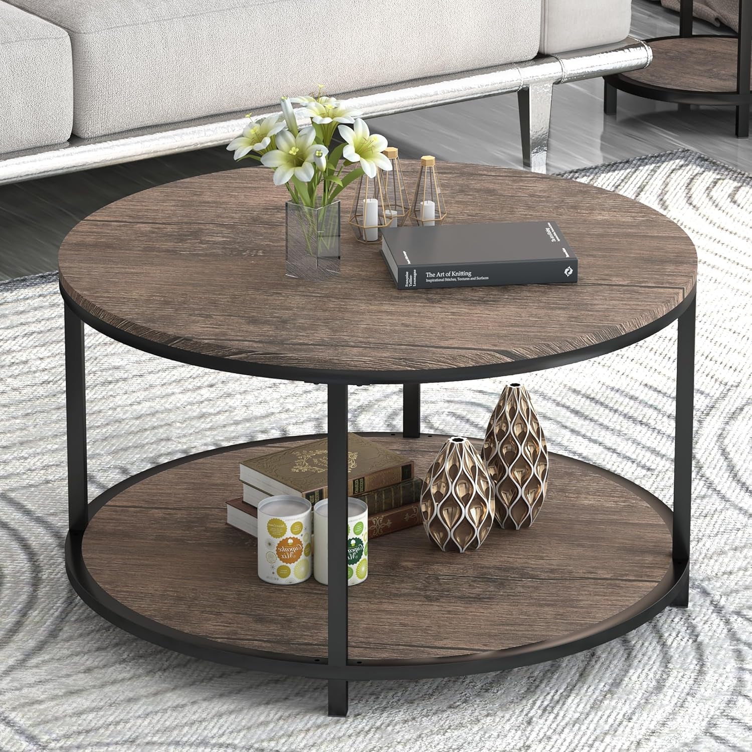 Round two-tier coffee table styled with a book, vase of flowers and decorative objects