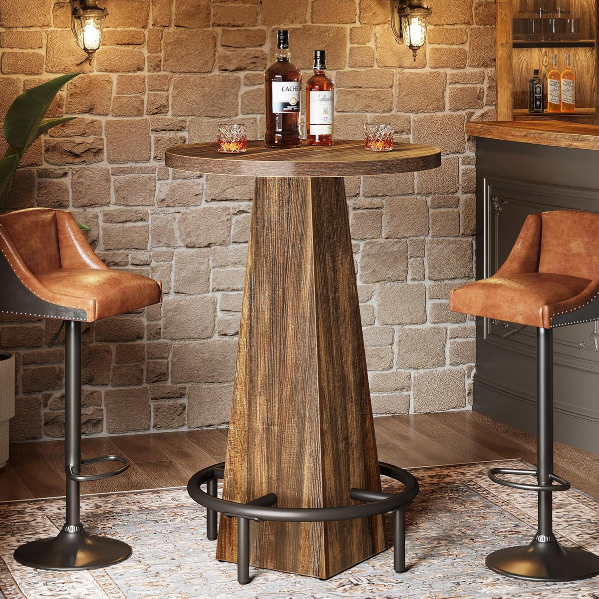 Round rustic brown bar table with bottles on top and black metal footrest ring, styled in a warm bar setting