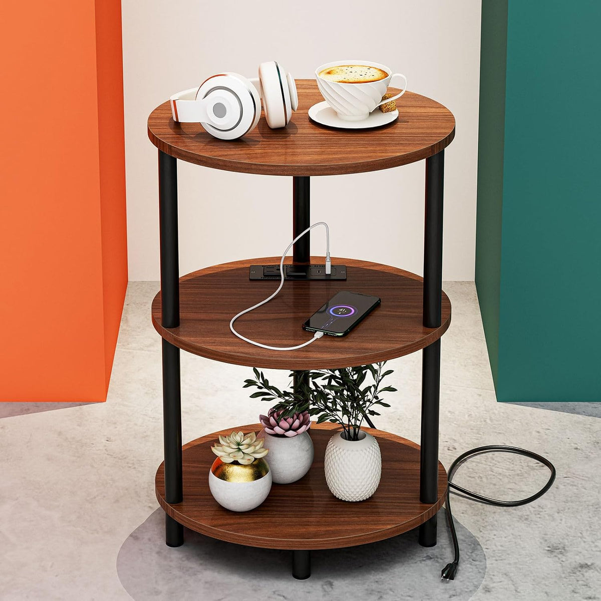 Round three-tier end table in warm wood finish with a phone charging cable and small plant decor.