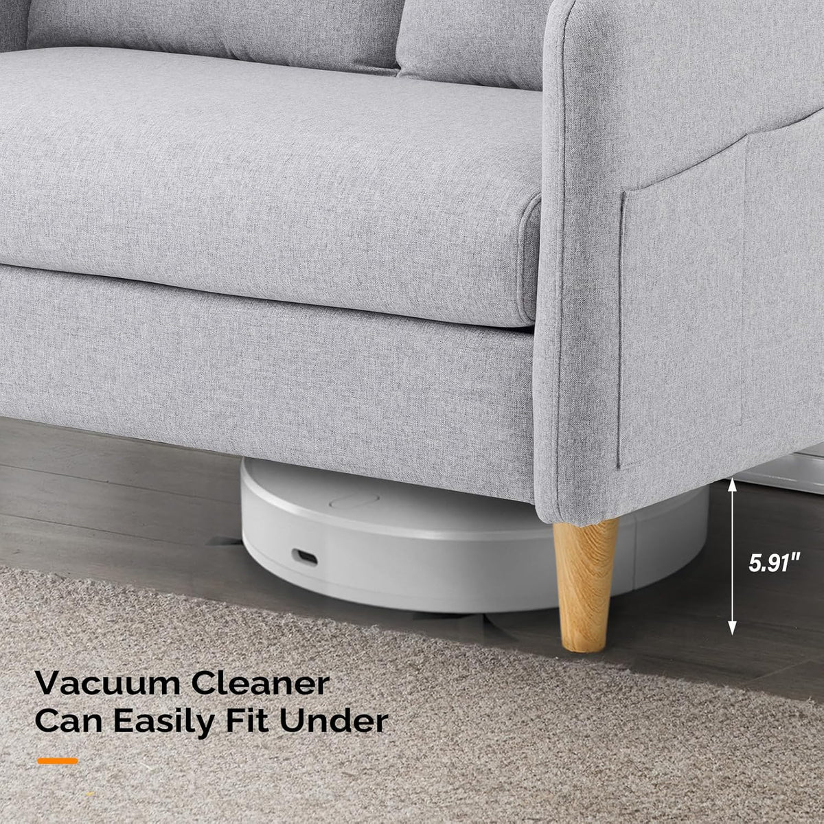 Close view under loveseat showing wooden tapered leg and a robot vacuum fitting beneath the frame.
