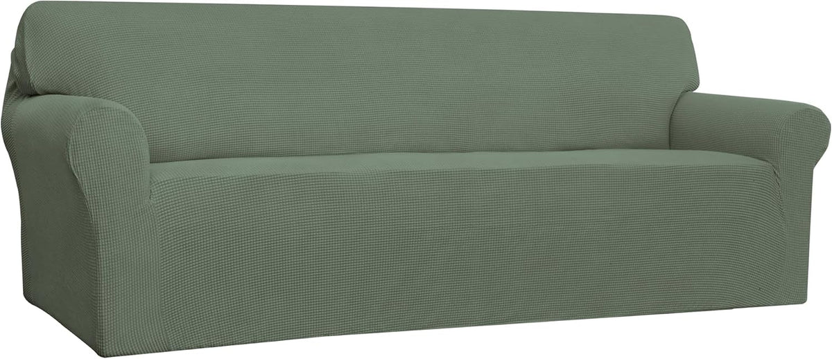 Three-quarter left view of a sage-green loveseat fully covered in a textured stretch slipcover.