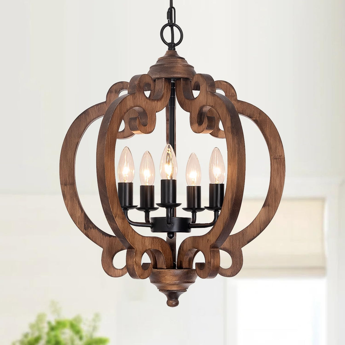 Ornate carved wood orb with scrollwork panels surrounding a five-light candle cluster and turned bottom finial