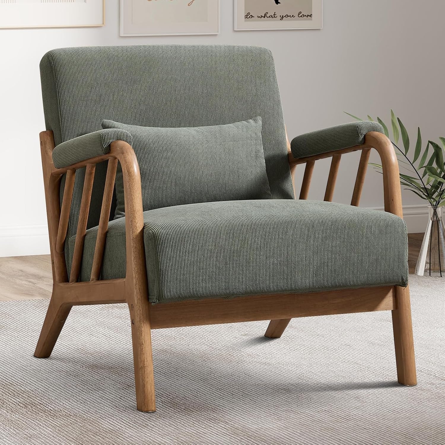 Mid-century accent chair with green ribbed upholstery, light wood angled frame and slatted arms, lumbar pillow in a neutral