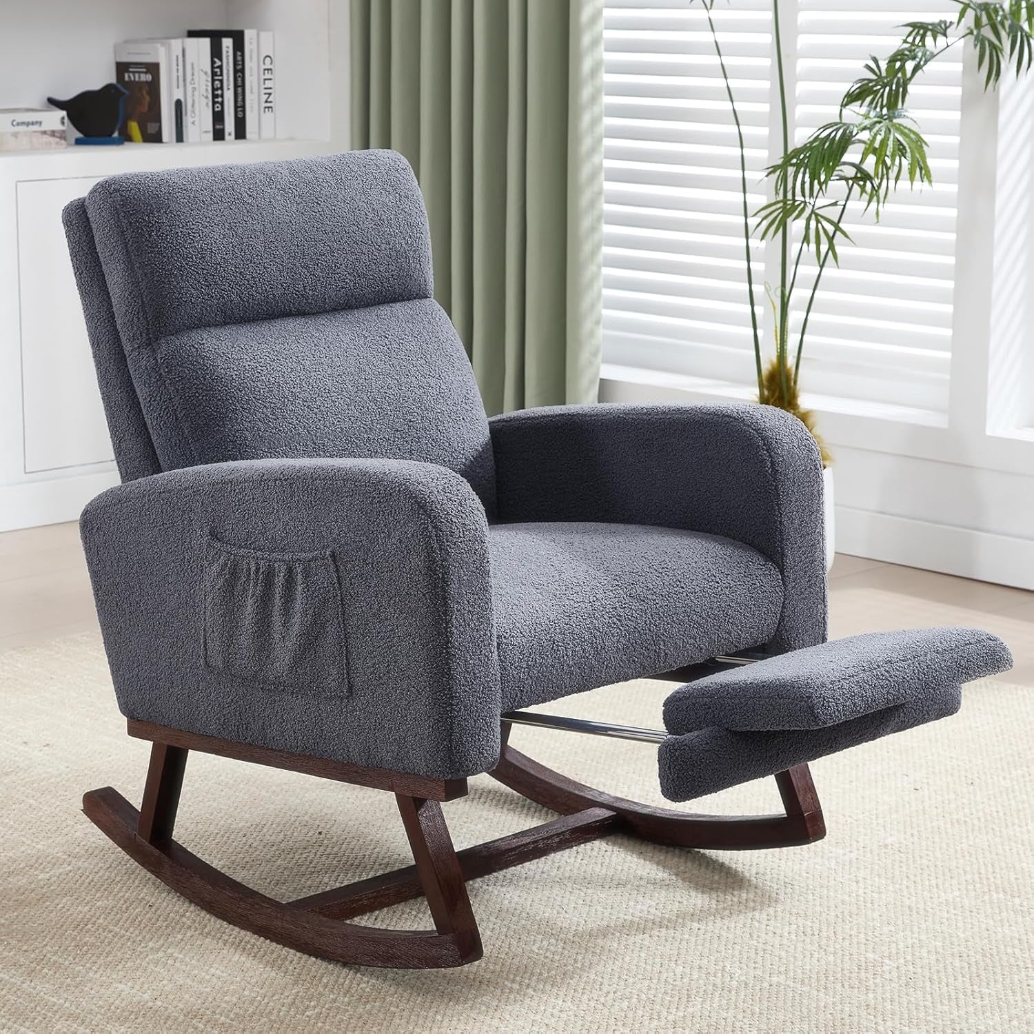 Gray upholstered rocker with dark wood base and padded footrest extended in bright room.