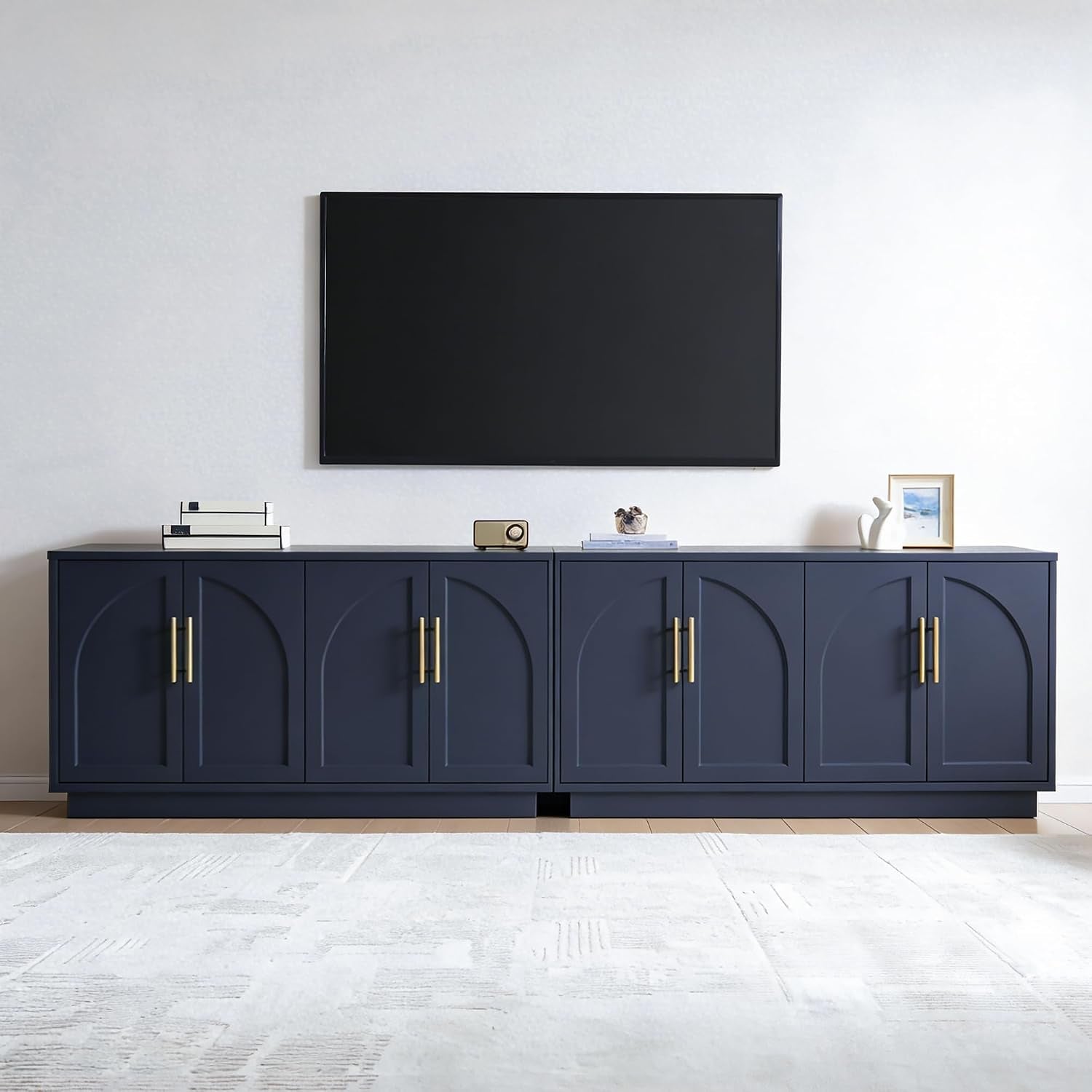 Wide shot of two navy cabinet sections placed side-by-side with a small gap beneath a wall-mounted TV.