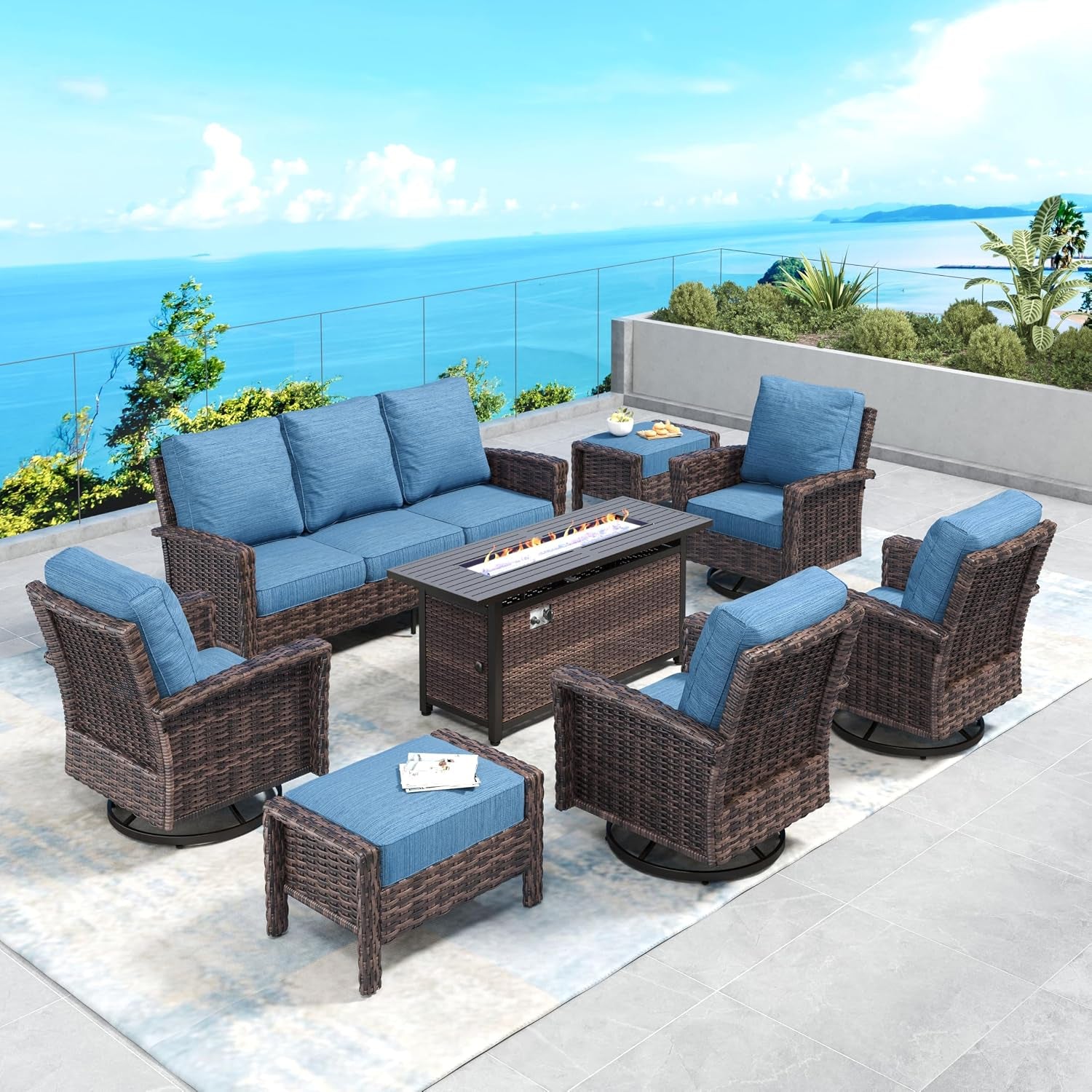 Outdoor wicker conversation set with blue cushions organized around a rectangular fire pit table on a pale area rug and