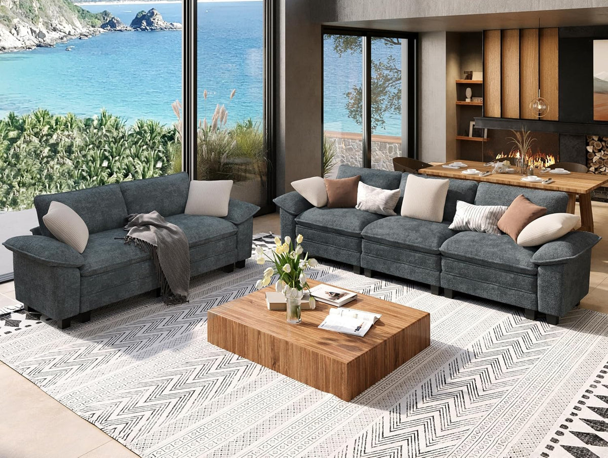Living room with two-piece sofa set: three-seat couch and loveseat in dark gray fabric, wooden coffee table, patterned rug