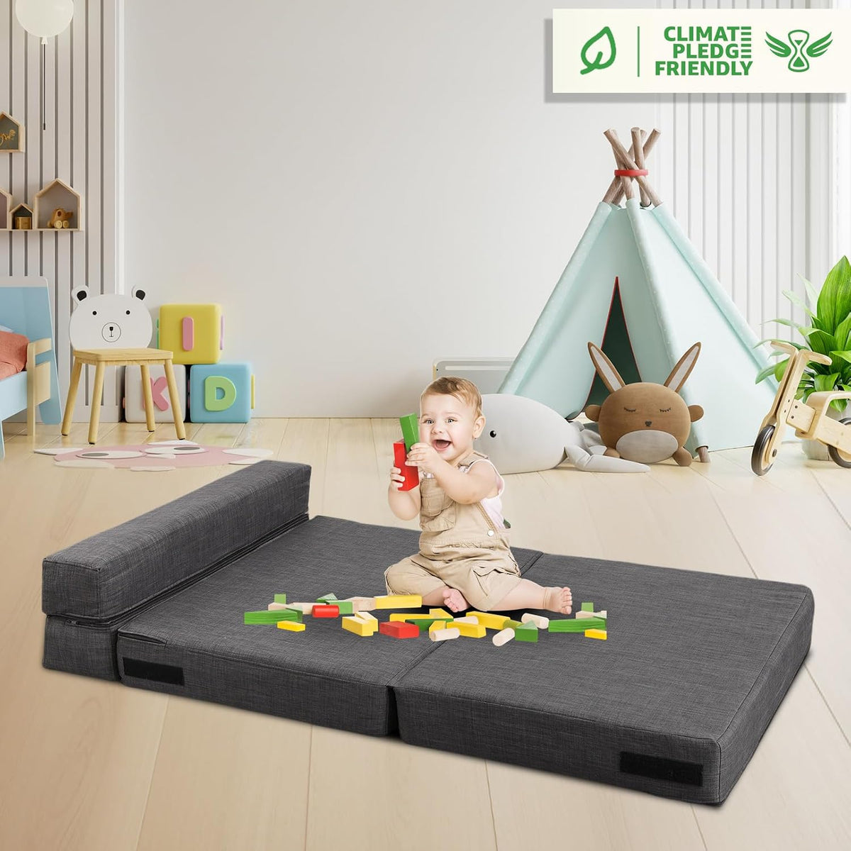 Dark gray futon mattress unfolded on the floor with a child playing on top