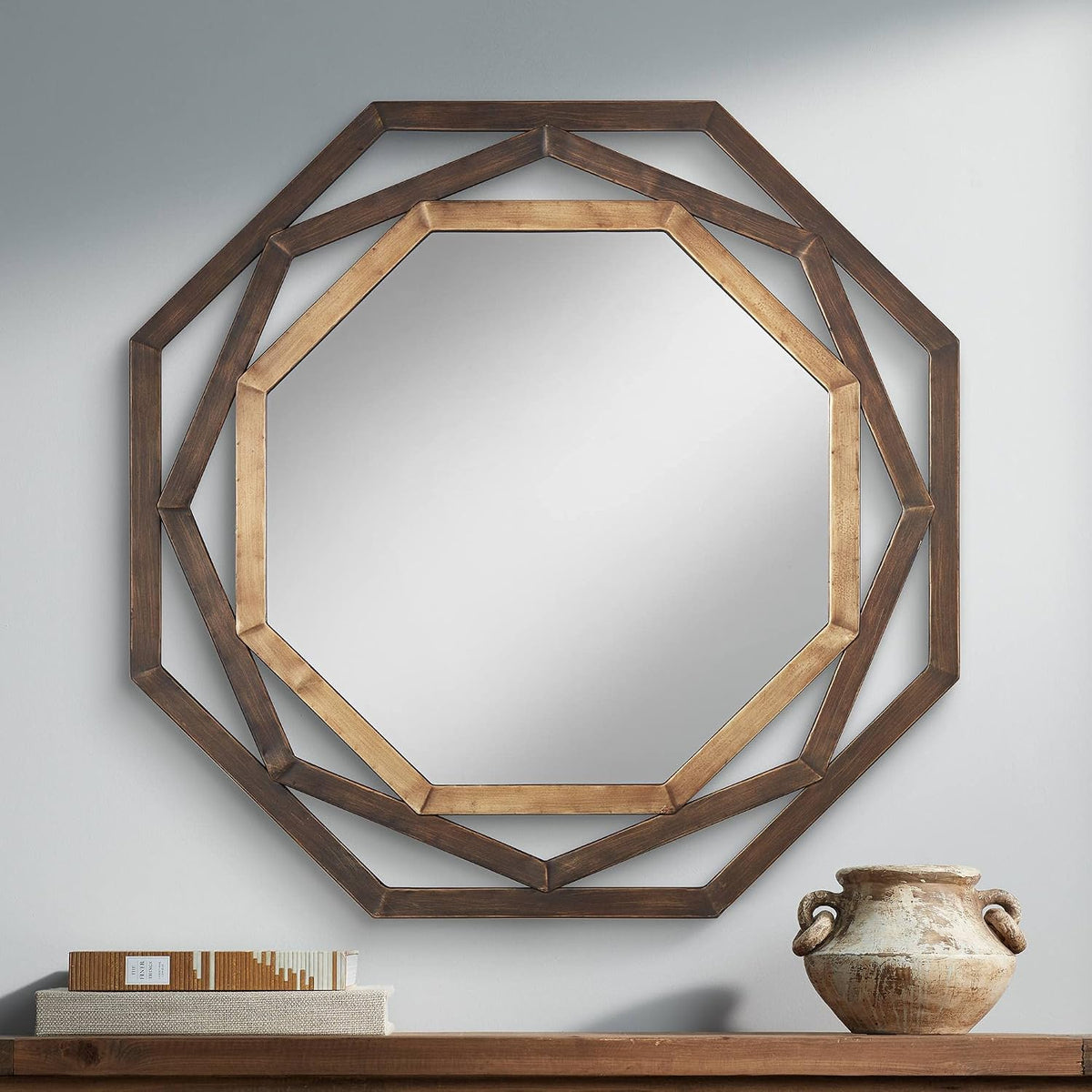 Close-up front view of octagonal openwork mirror showing inner golden bronze frame and outer deep bronze layer