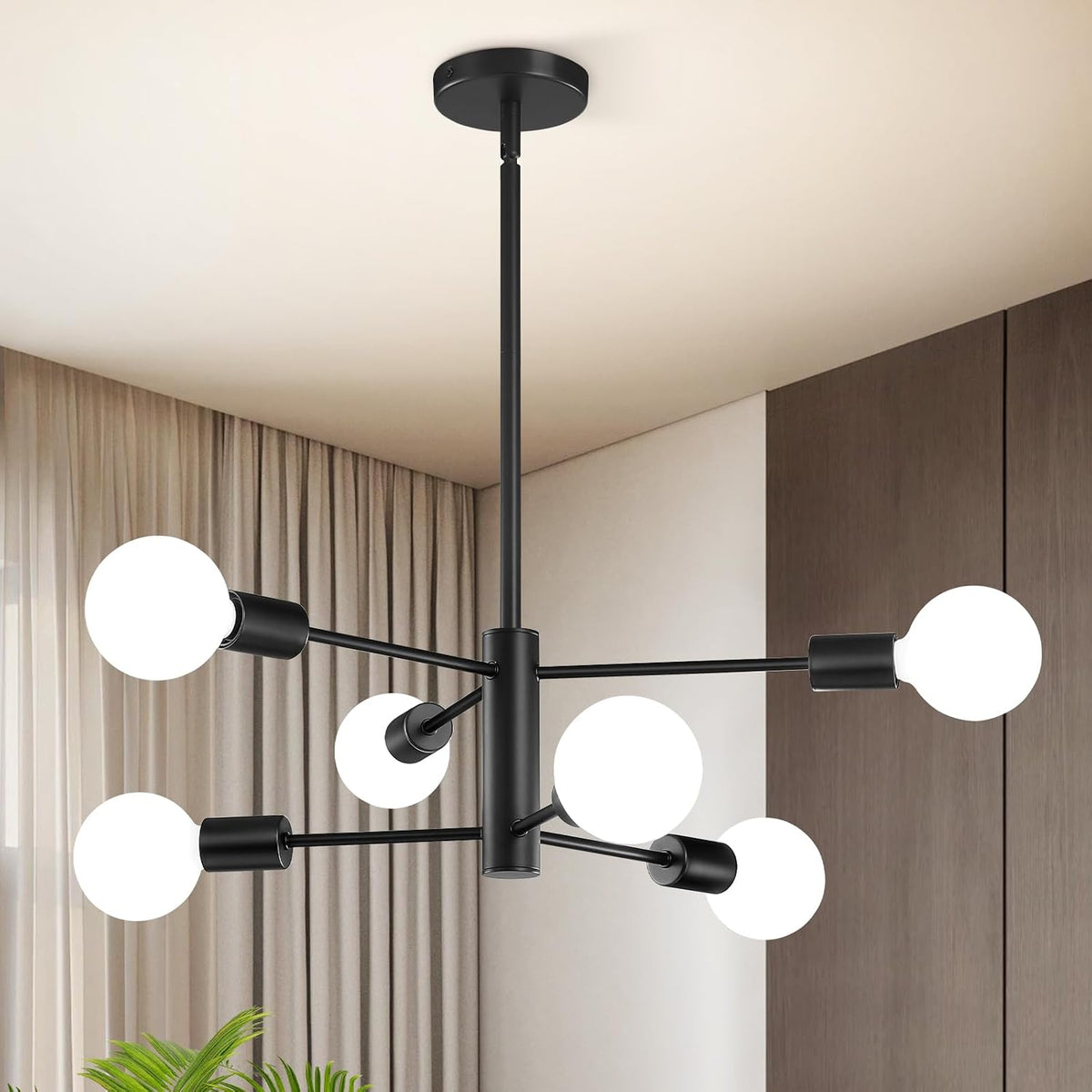 Black sputnik chandelier with glowing round bulbs suspended from a ceiling over a curtained corner.