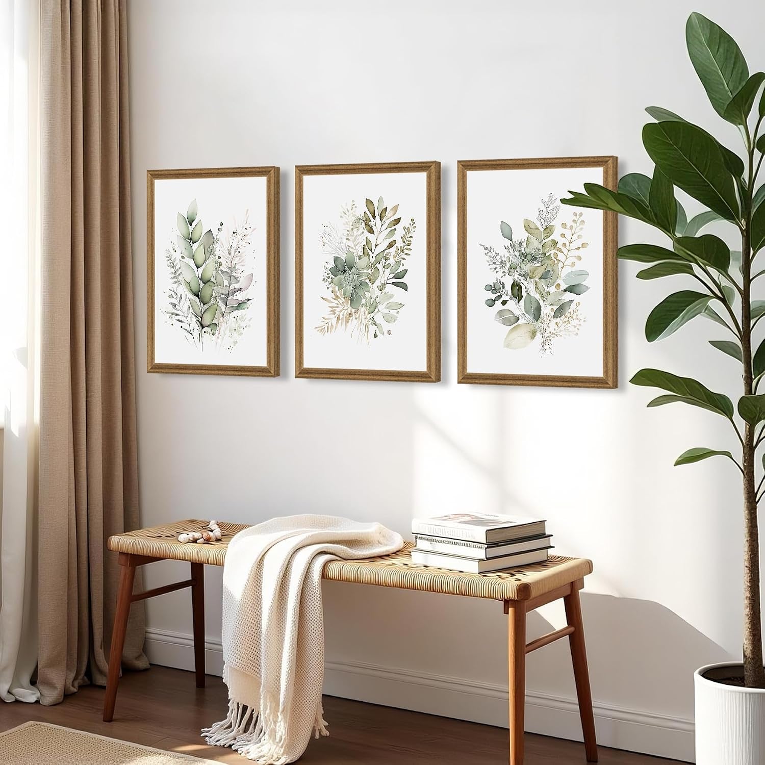 Three framed botanical canvases hung in a hallway above a woven bench with neutral curtains at the side