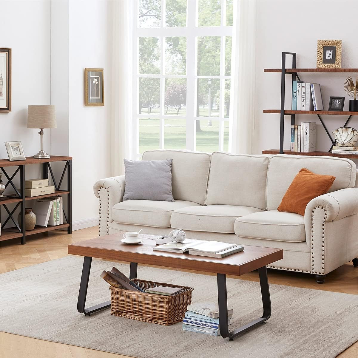Low rectangular coffee table in front of cream sofa, with bookshelf, lamp and large window in background.