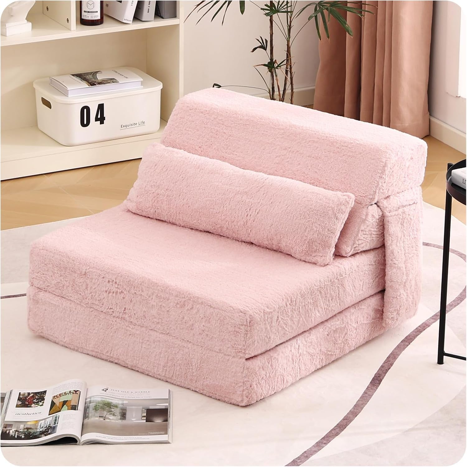 Light pink plush foldable sofa bed chair with faux-fur cover and matching pillow in a cozy corner.