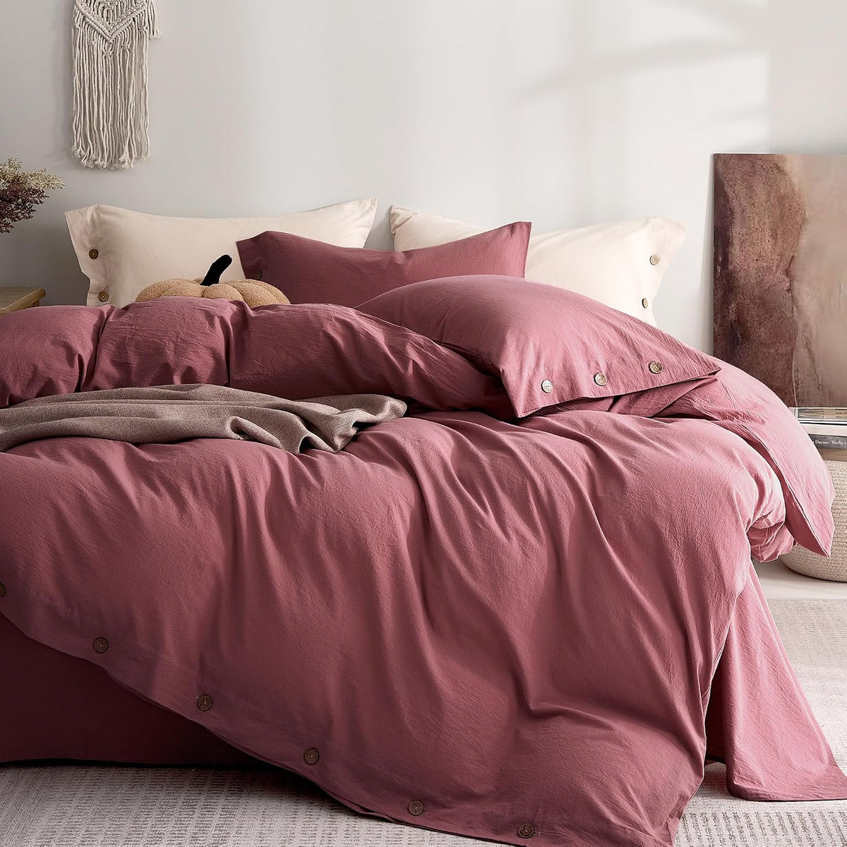 Soft rose-pink duvet and pillow set on a bed with button closures visible along the edge.