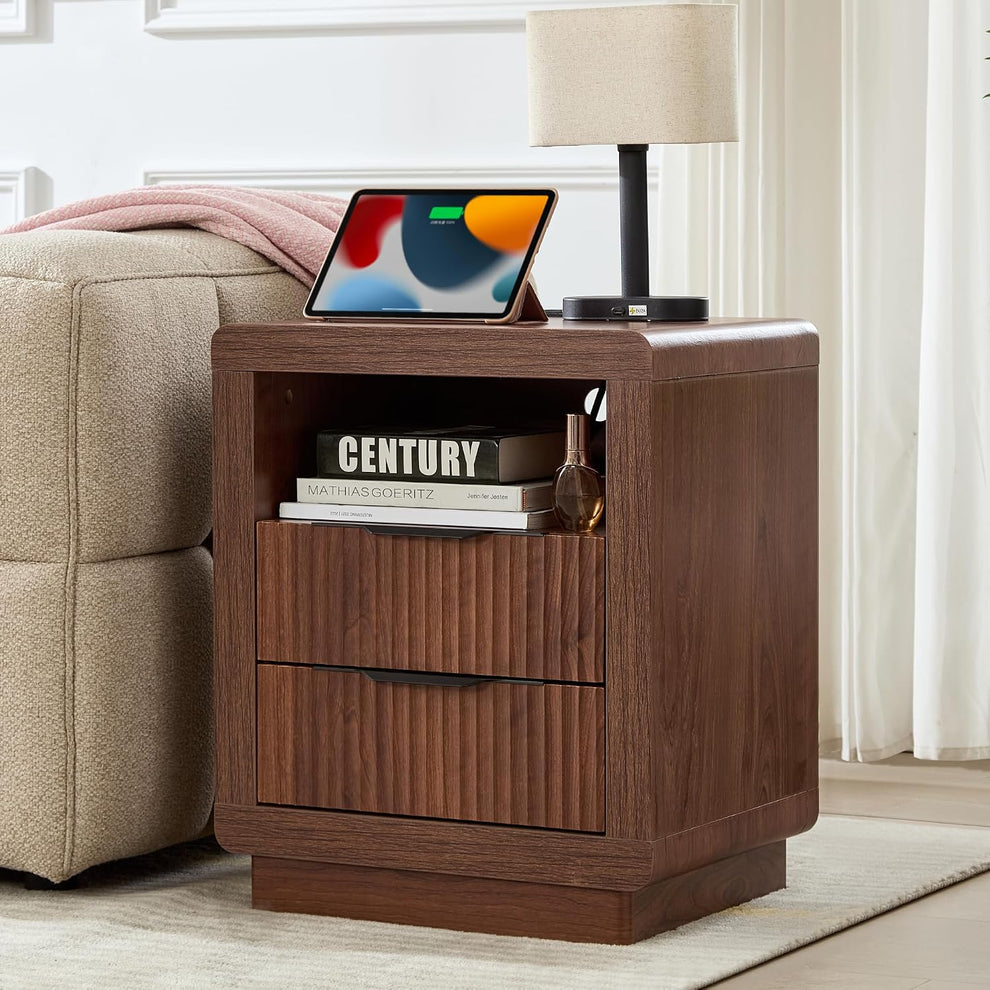 Walnut finish fluted nightstand beside a sofa showing open shelf and two fluted-front drawers, angled front view