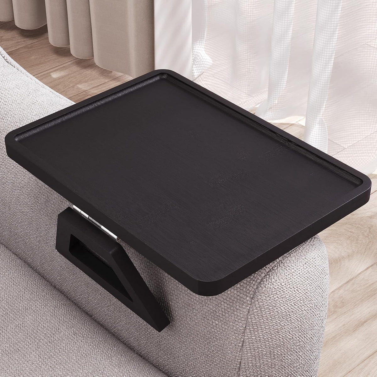 Black tray shown mounted on a sofa, highlighting the recessed lip and dark painted surface