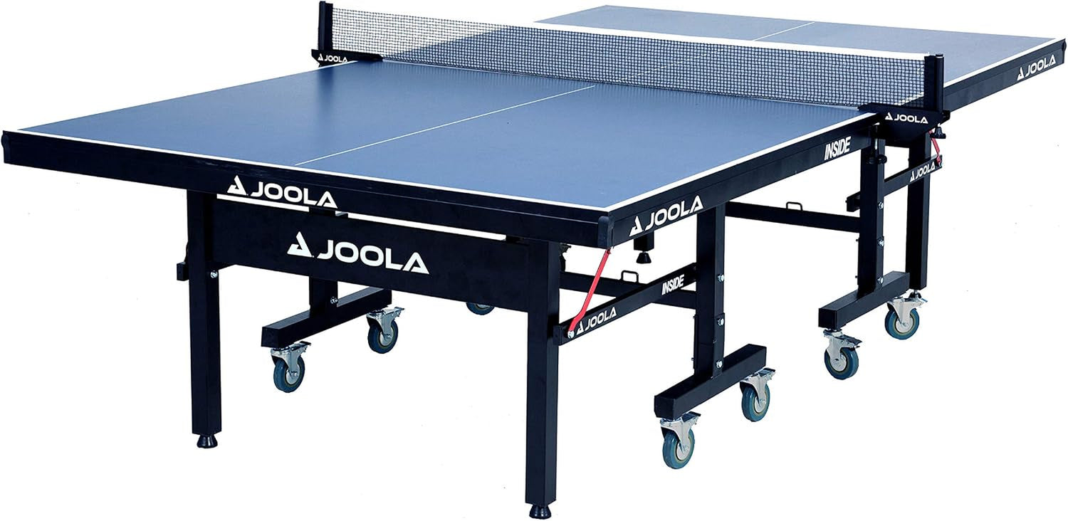 Low-angle view of blue tabletop edge and underframe showing metal legs, caster wheels, and a red safety strap.