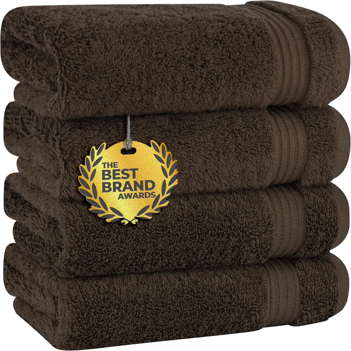 Three deep brown towels stacked horizontally with visible ribbed bands and a gold award medallion tucked between layers.