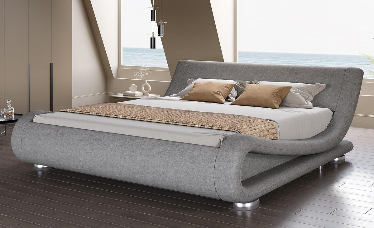 Angled side view of a light gray upholstered wave platform bed showing its rolled foot and silver legs