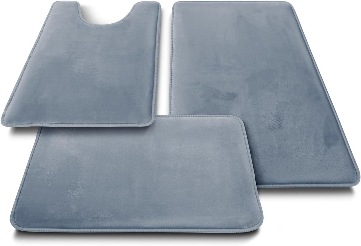 Three-piece set of stone-blue velvet bathroom rugs arranged side by side.