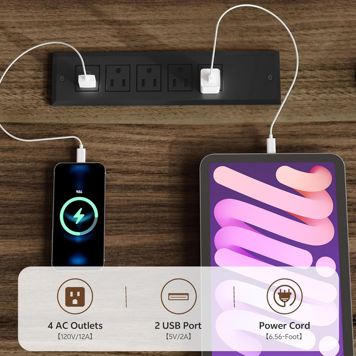Black integrated charging station mounted in the walnut desktop with two USB cables powering a phone and a tablet