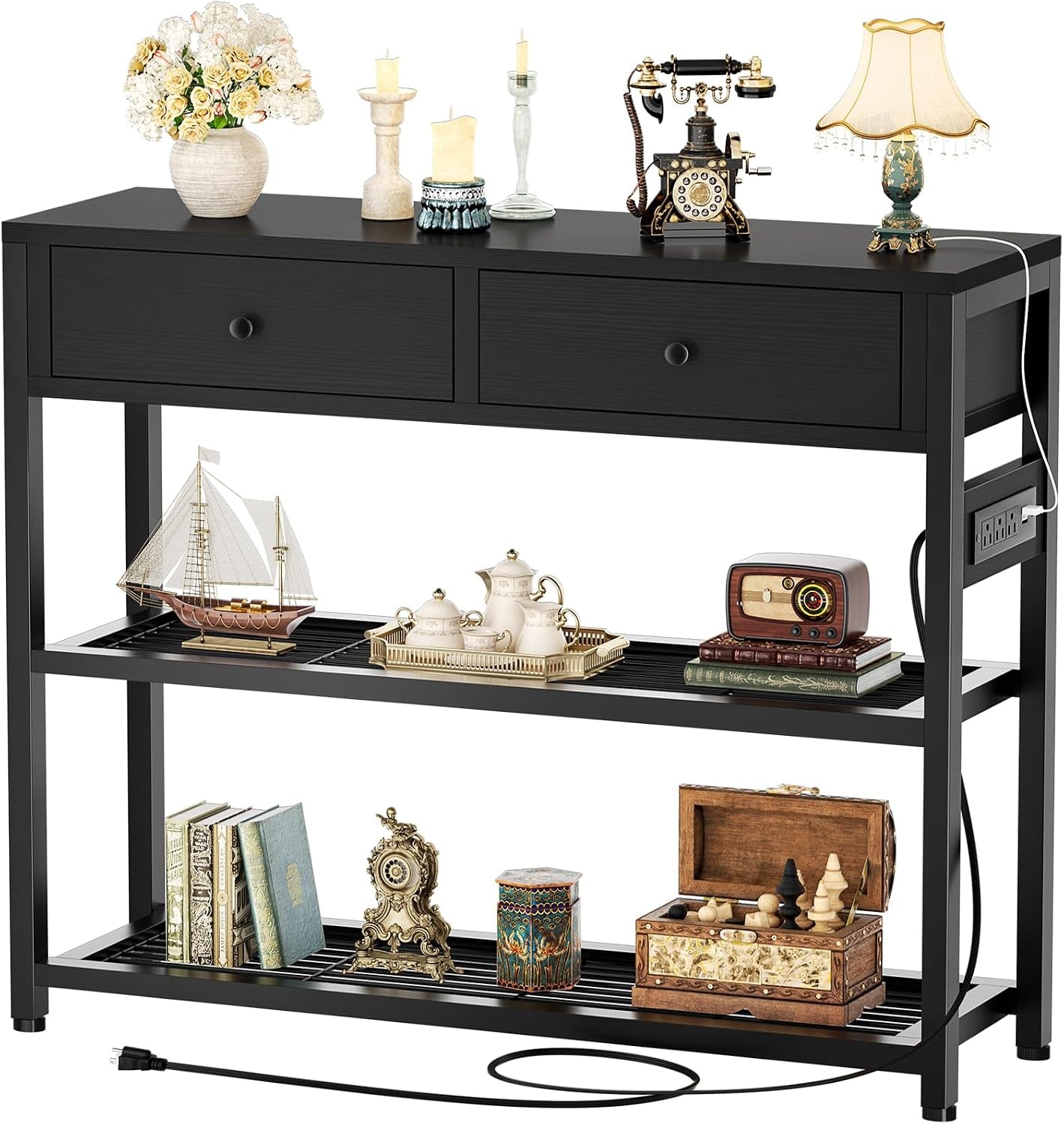 Angled view of black console table showing two upper drawers, slatted lower shelves and accessories atop