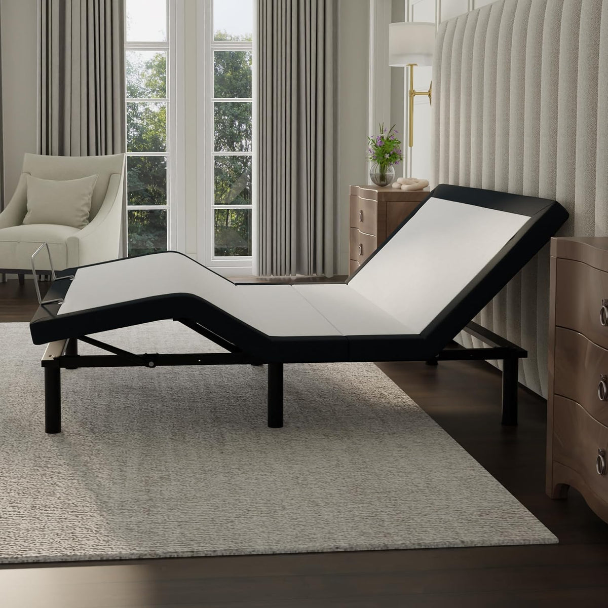 Black adjustable bed base with white deck shown raised in a bedroom setting, side view