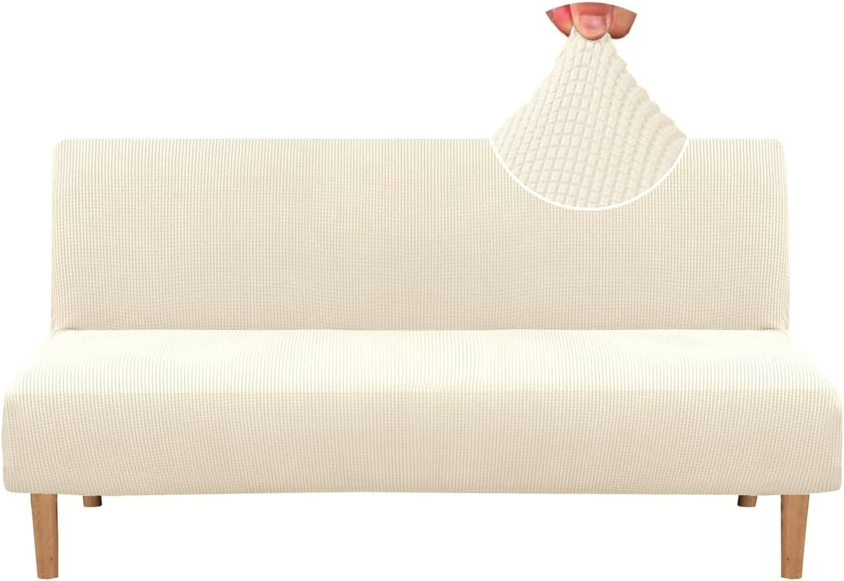 Front view of a futon covered in a textured small-check cream slipcover with wooden legs visible