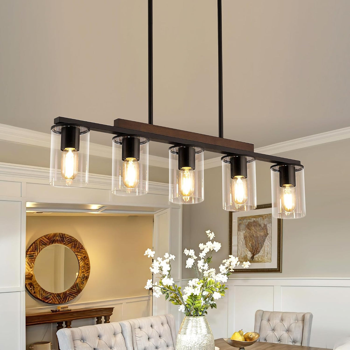 Close-up angled view of the five-light matte black fixture with clear glass shades and wooden accent bar
