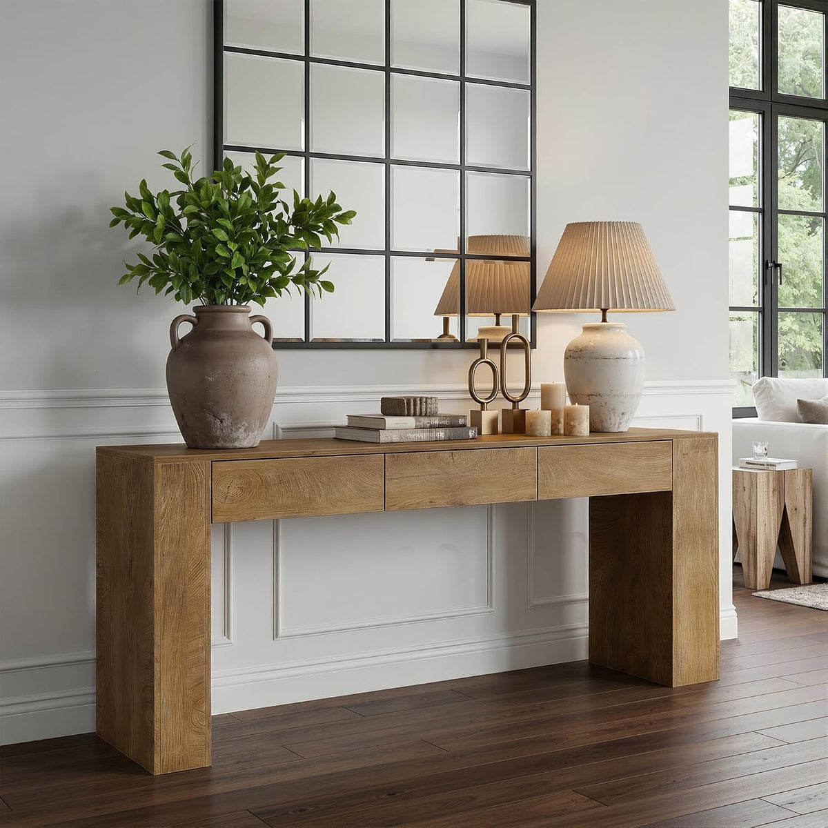 Three-quarter view of the rustic brown console highlighting its thick block legs, wood grain, potted vase and lamp.