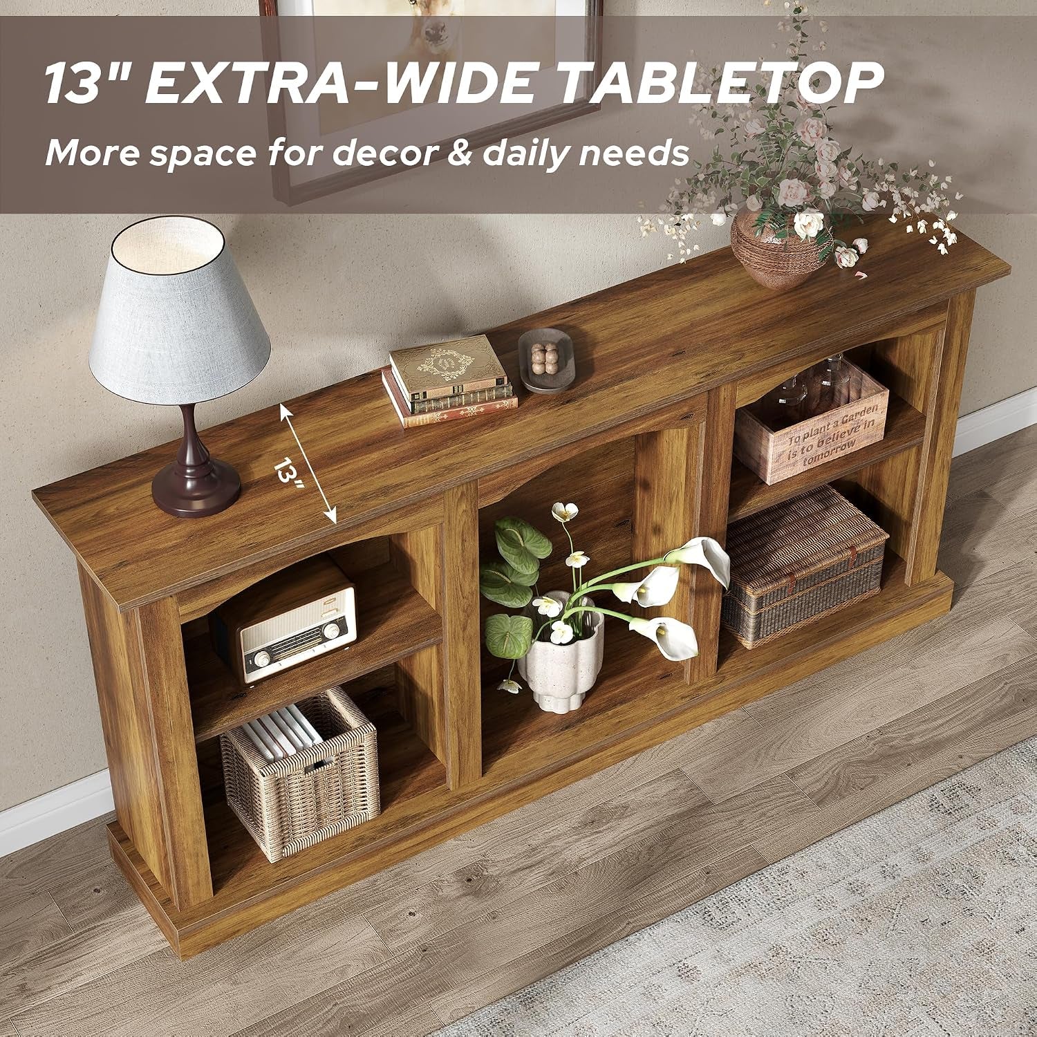 Angled top-down view of a rustic brown arched console table styled with a lamp, books, potted flowers, and woven baskets in