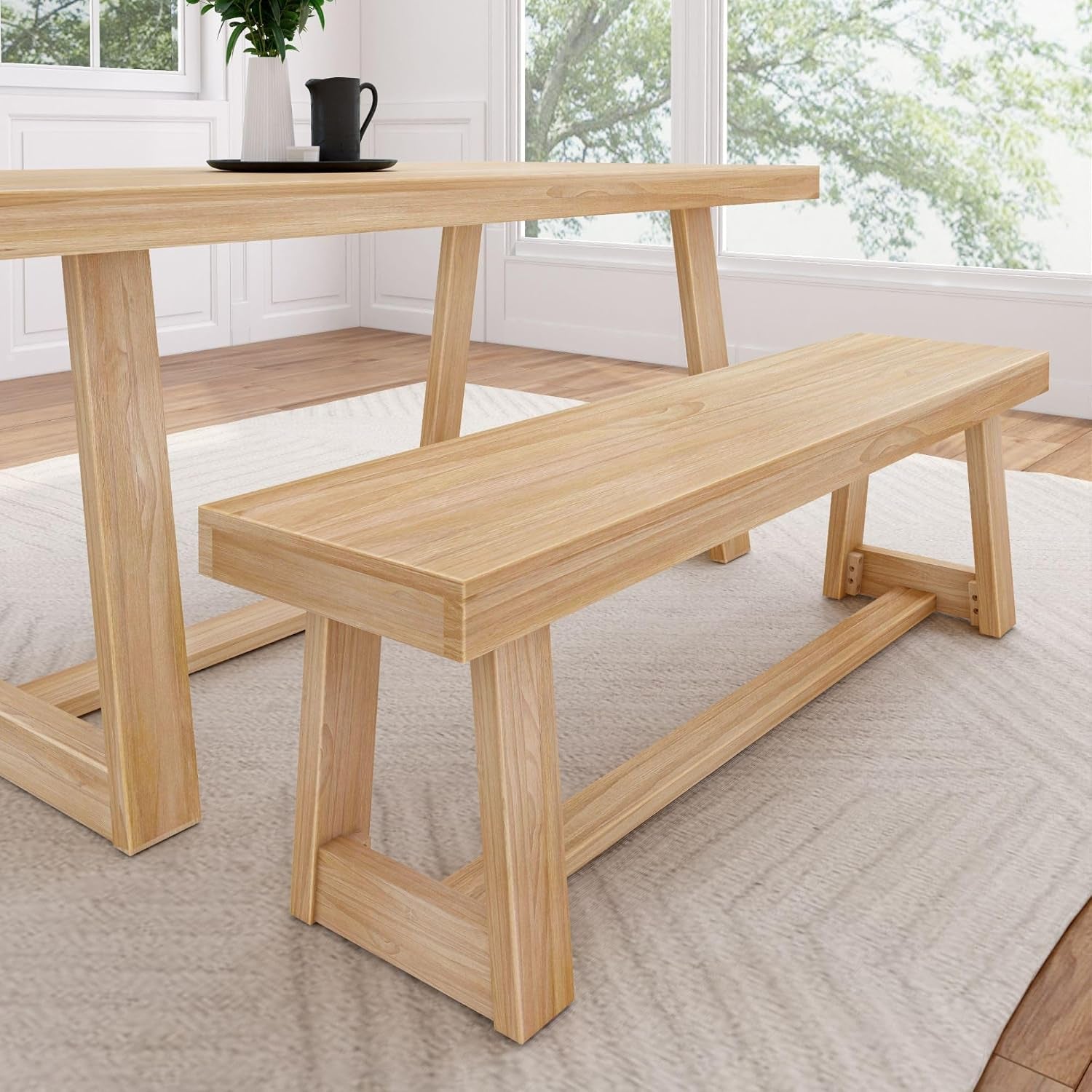 Close side view of a pecan wood bench and the table leg on a light rug.