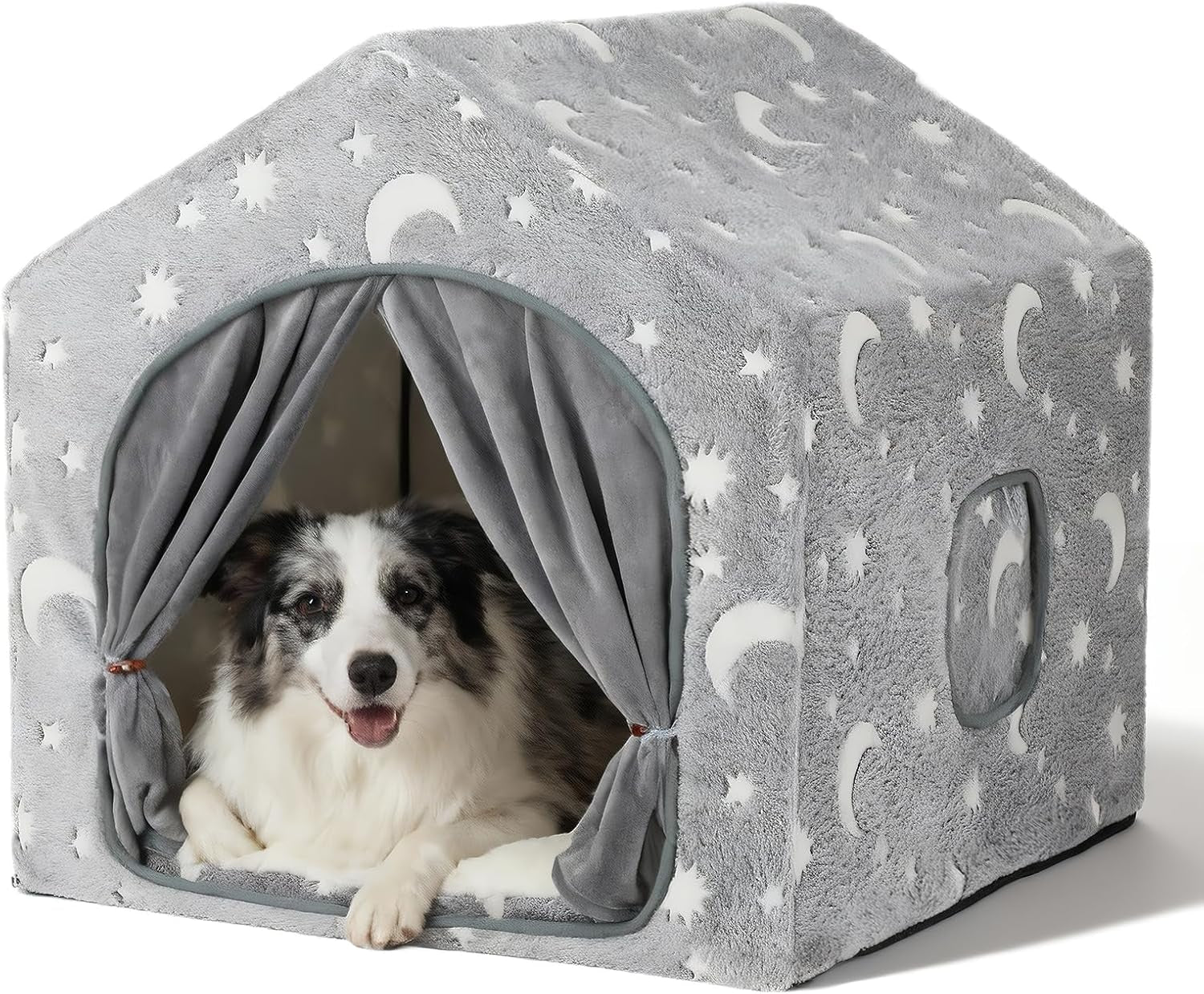 Grey plush indoor dog house with moon-and-star pattern front view showing dog inside and tied curtains