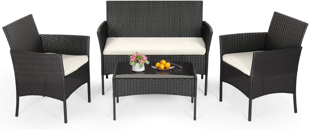 Four-piece outdoor rattan conversation set with loveseat, two armchairs and glass-top coffee table on white background