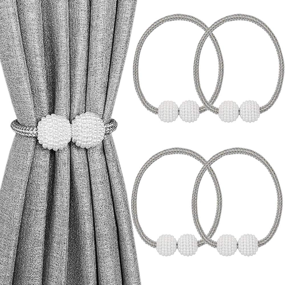 Gray braided magnetic tiebacks with two white textured beads displayed alongside a pleated gray curtain.