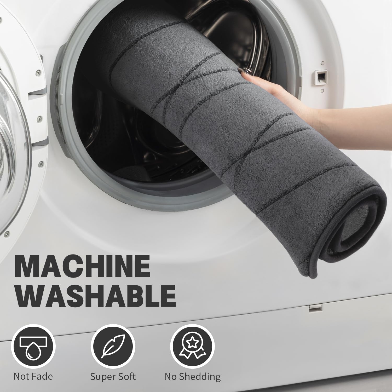 Dark grey bath rug rolled and inserted into a washing machine to illustrate machine-washable care