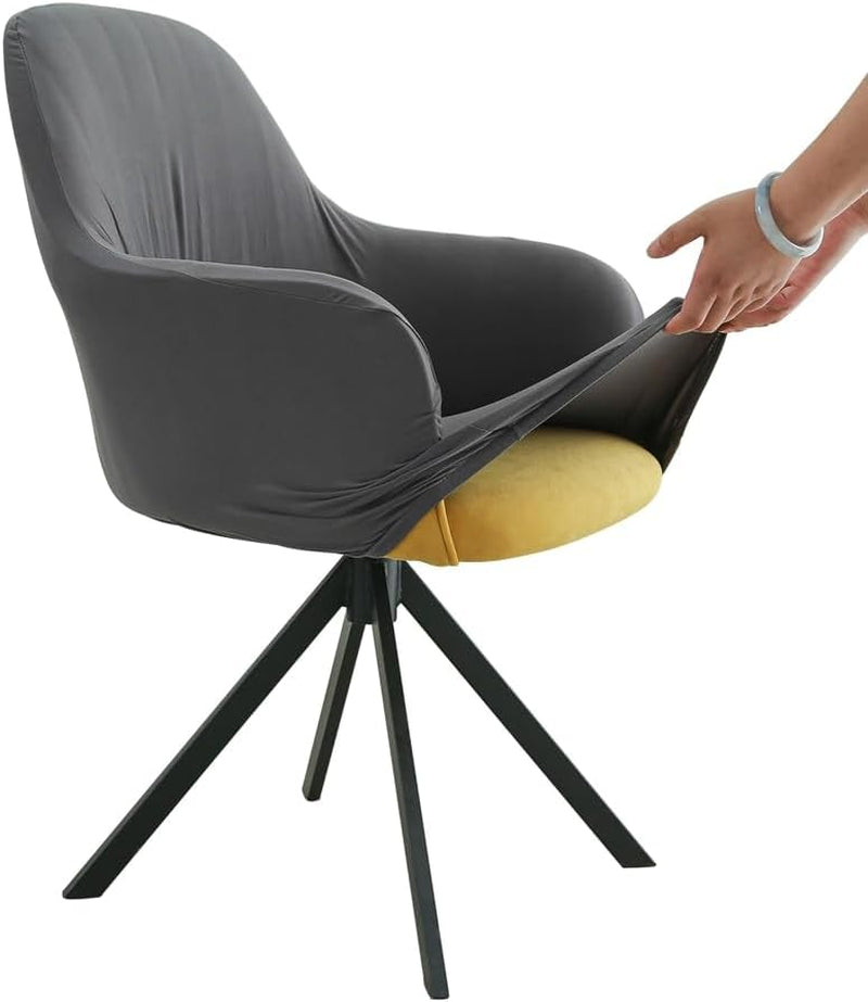 Three-quarter side view of a dark gray chair cover being stretched over a swivel armchair by hands.