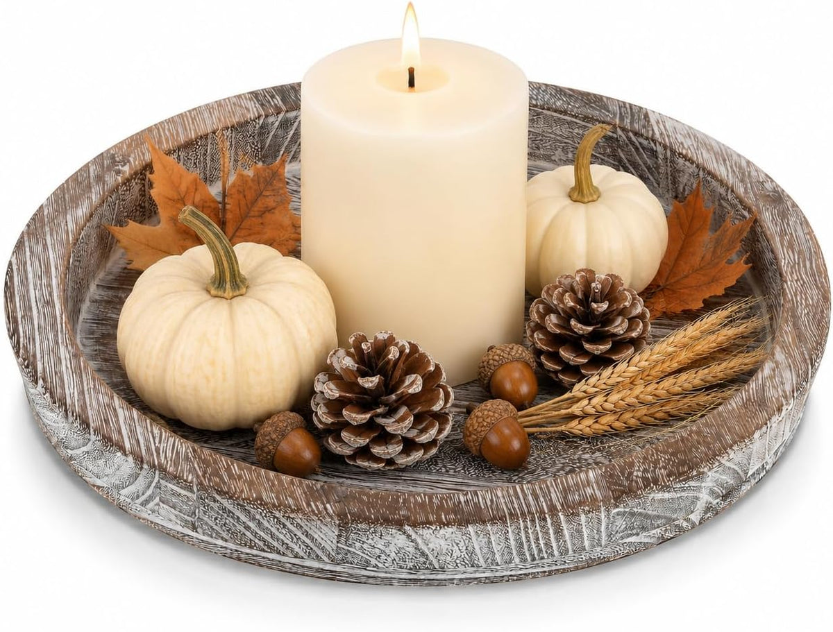 Wooden tray styled with a large lit candle, small white pumpkins, pinecones, acorns and wheat stalks